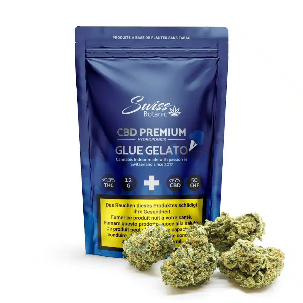 Un emballage bleu de Swiss Botanic Fleurs de CBD indoor Glue Gelato - 0,3 % THC se tient droit avec des bourgeons de cannabis devant, affichant les détails du produit et une étiquette d'avertissement claire.