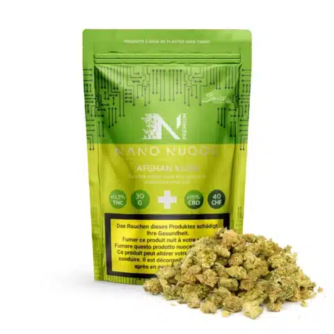 Un sachet vert refermable étiqueté "fleurs de cbd indoor nano nuggs - afghan kush - 0,3% thc" se trouve derrière les bourgeons de cannabis, avec des détails en français sur le thc, le cbd, le poids et le prix, mettant en valeur la variété premium afghan kush nano nuggs.