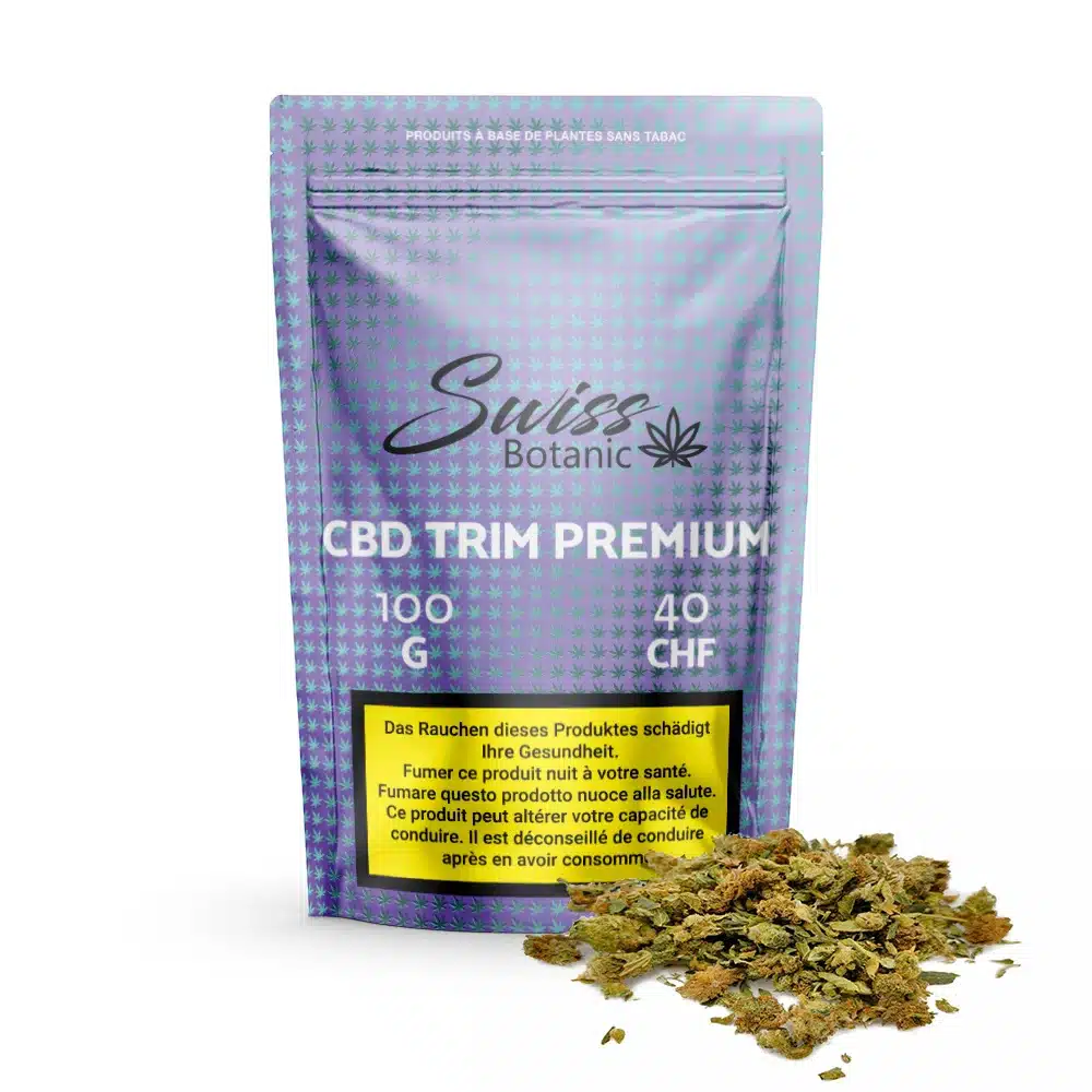 Fleurs de cbd indoor trim premium 100g – 0. 3% thc 1 Un paquet de 100 g de fleurs de cbd indoor trim premium (0,3 % de thc), au prix de 40 chf, avec une étiquette d'avertissement et un petit tas de cannabis séché devant.