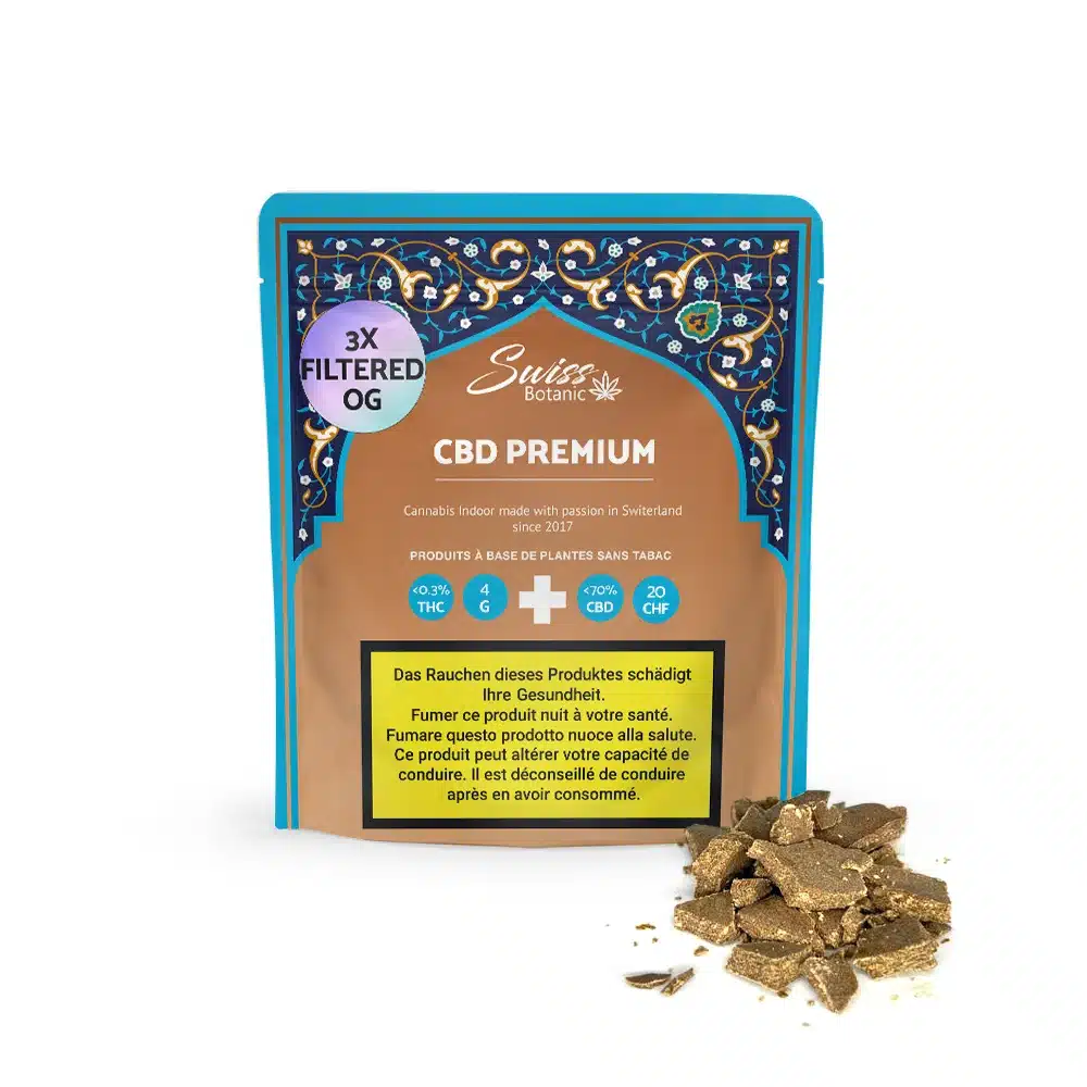3x filtered og hash cbd premium - 1 A pouch labeled "3x filtered og hash cbd premium" stands upright, displaying brown cbd hash in front. The packaging features blue and gold accents with health warning labels.