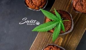 Brownies de cbd sobre una tabla de cortar de madera con una hoja de cannabis.