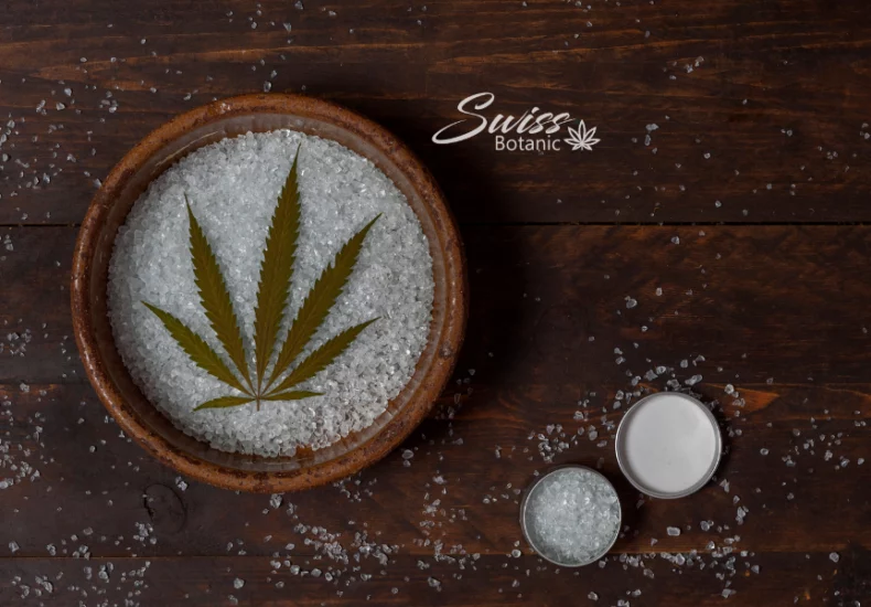 Cristaux de cbd 8 Un bol de sel avec une feuille de marijuana dessus.
