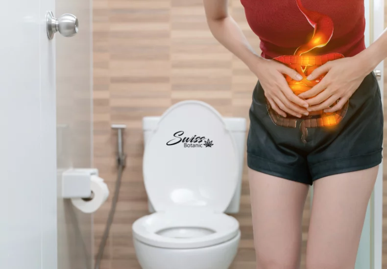 A woman standing in front of a toilet with a burning stomach, seeking relief with cbd.