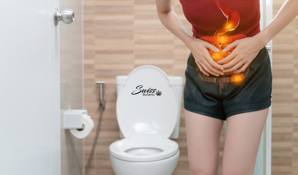 A woman standing in front of a toilet with a burning stomach, seeking relief with CBD.