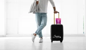 Un homme avec une valise et une bouteille d’eau.