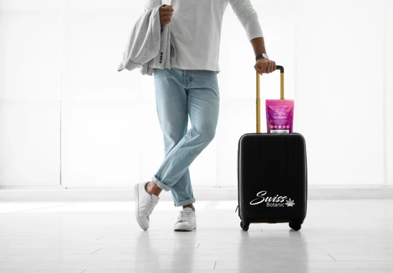 Voyager avec du cbd en avion : ce qu'il faut savoir 2 Un homme avec une valise et une bouteille d’eau.