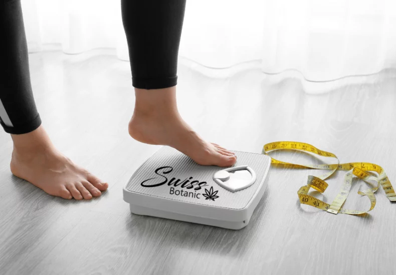 A woman's feet on a scale with a tape measure.