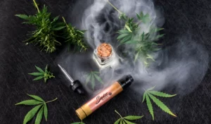 Huile de CBD et feuilles de cannabis sur fond noir.