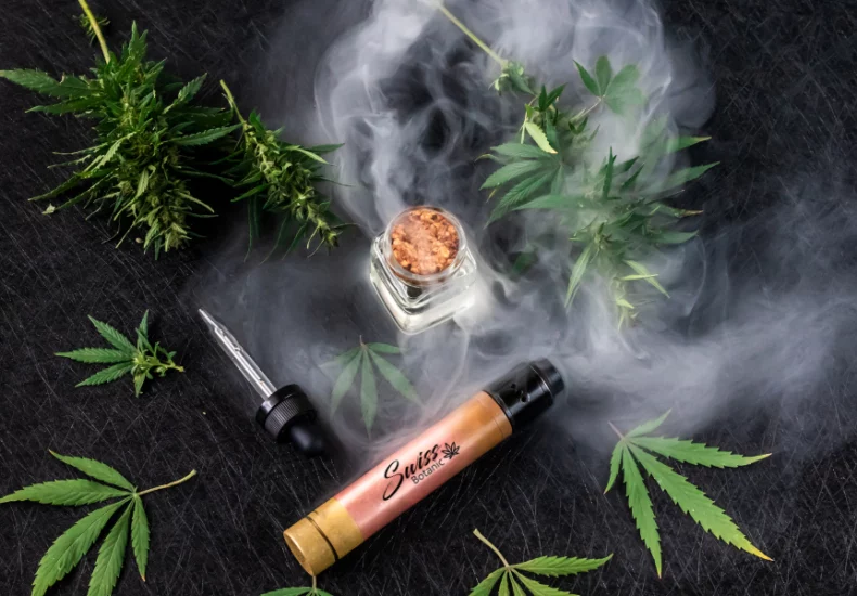 Cigarette électronique cbd 2 Huile de cbd et feuilles de cannabis sur fond noir.