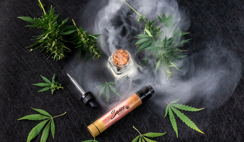 Huile de CBD et feuilles de cannabis sur fond noir.