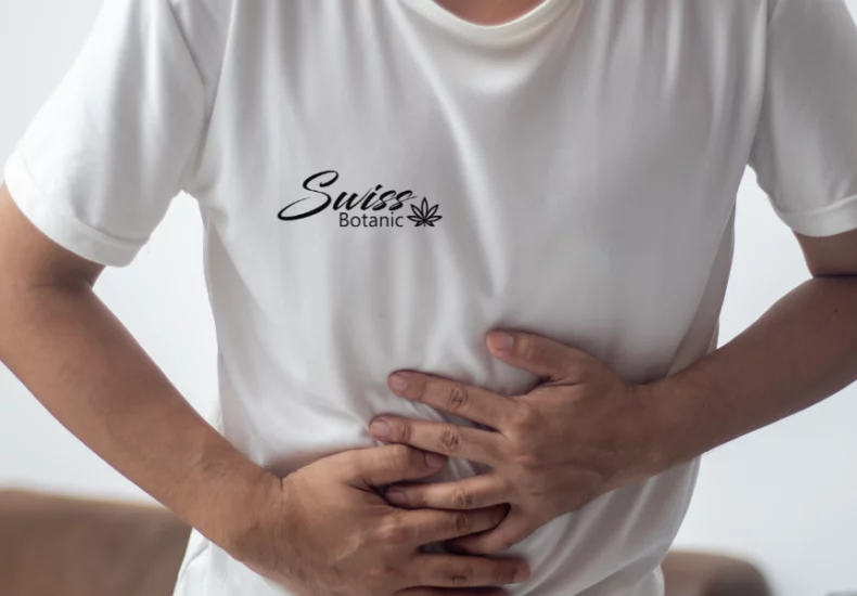 Un hombre sosteniendo su estómago con una camiseta blanca.