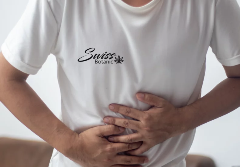 Bellyache relief with cbd: complete guide 8 A man holding his stomach in a white t - shirt.