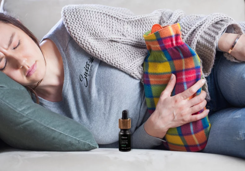 Cbd and painful periods: a natural solution to ease the pain 4 A woman laying on a couch with a pillow.