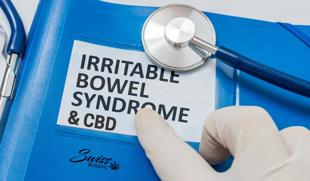 A gloved hand rests on a blue folder with a stethoscope, alongside a printed paper that reads "irritable bowel syndrome & cbd.