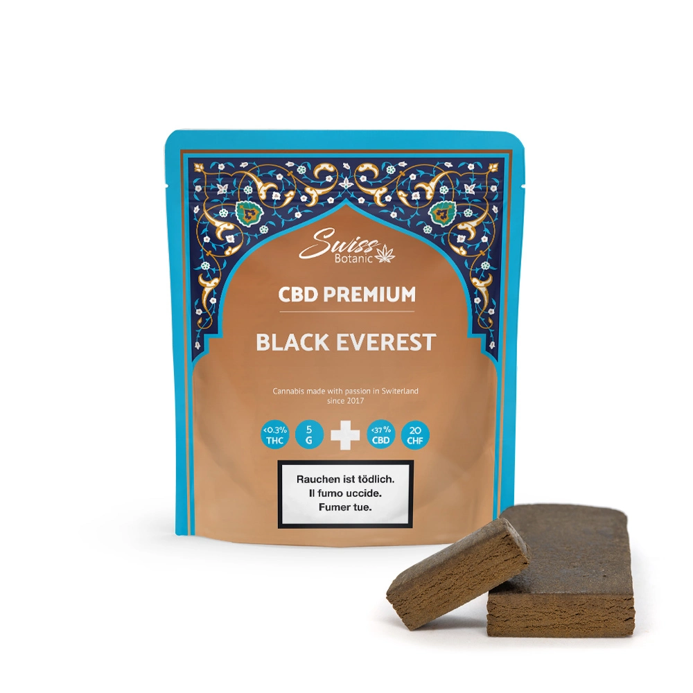 Paquete de CBD Premium Black Everest de Swiss Botanic con dos bloques de producto en el frente. Contiene menos del 0,3 % de THC y alrededor del 21 % de CBD. El empaque es ornamentado y colorido.