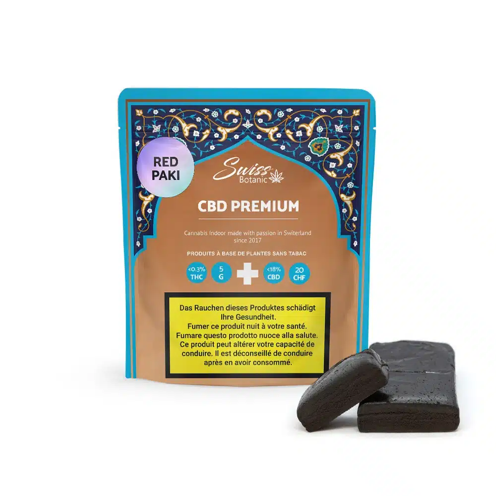 A colorful package labeled "Red Paki Hash CBD Premium - 0.3% THC" displays two dark solid pieces in front, along with health warnings in several languages.