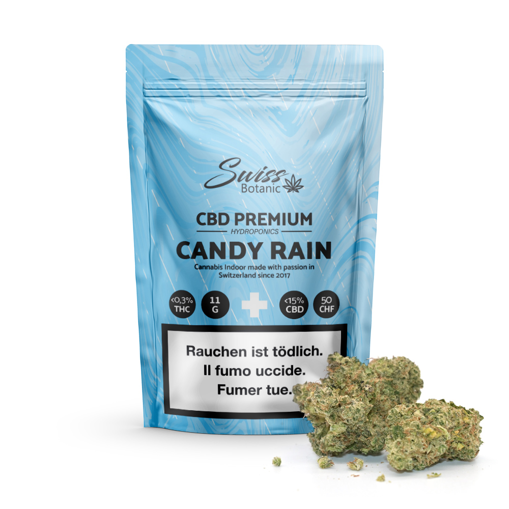 Fleurs de CBD indoor Candy Rain – 0,3 % THC" comprend un sachet bleu contenant 15 % de CBD, de petites têtes de cannabis vertes et des étiquettes d'avertissement multilingues garantissant clarté et sécurité pour votre expérience premium.