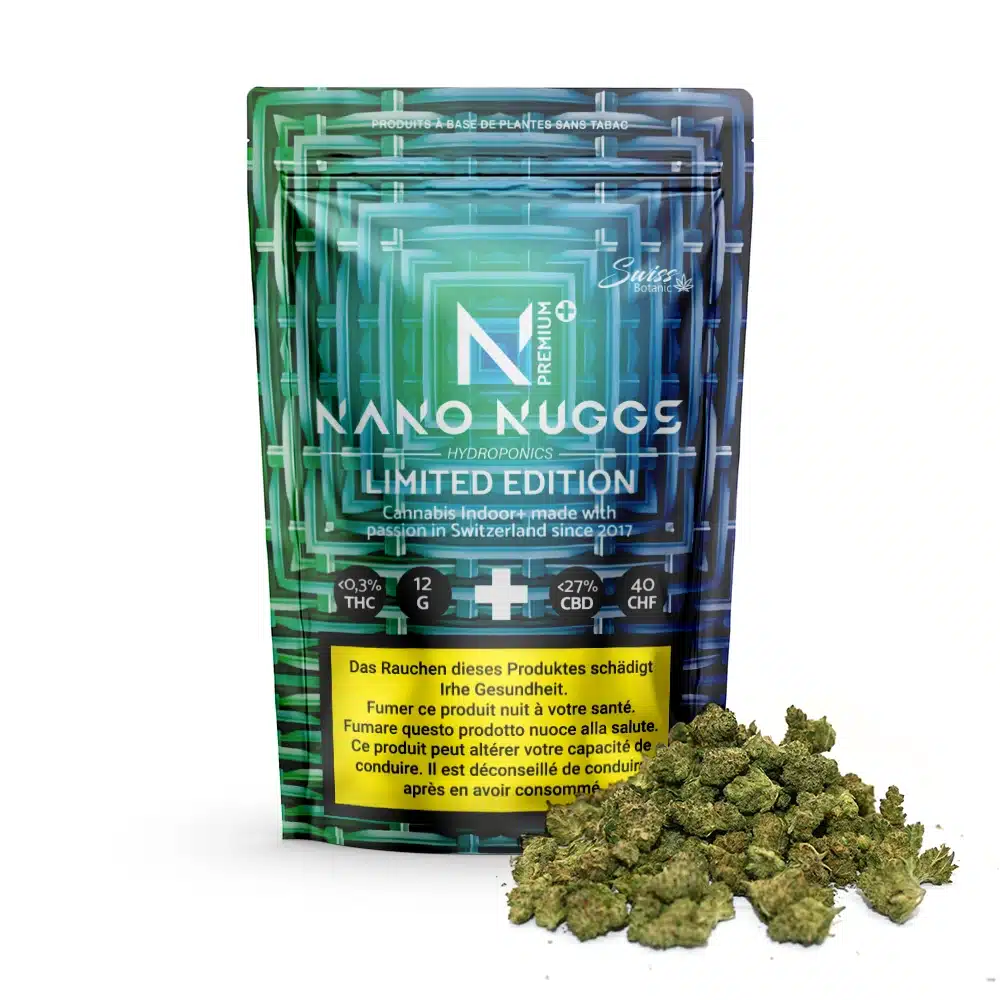 A package labeled "Indoor CBD Flowers Nano Nuggs Premium Limited Edition - Blue - 0.3% THC" stands upright with a pile of dried cannabis buds in front.