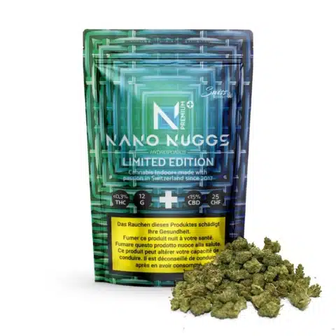 Un paquet bleu étiqueté "fleurs de cbd indoor nano nuggs premium limited edition" (0,3 % de thc) avec des bourgeons de cannabis devant ; l'emballage comporte des informations sur le produit et des avertissements sanitaires en plusieurs langues.