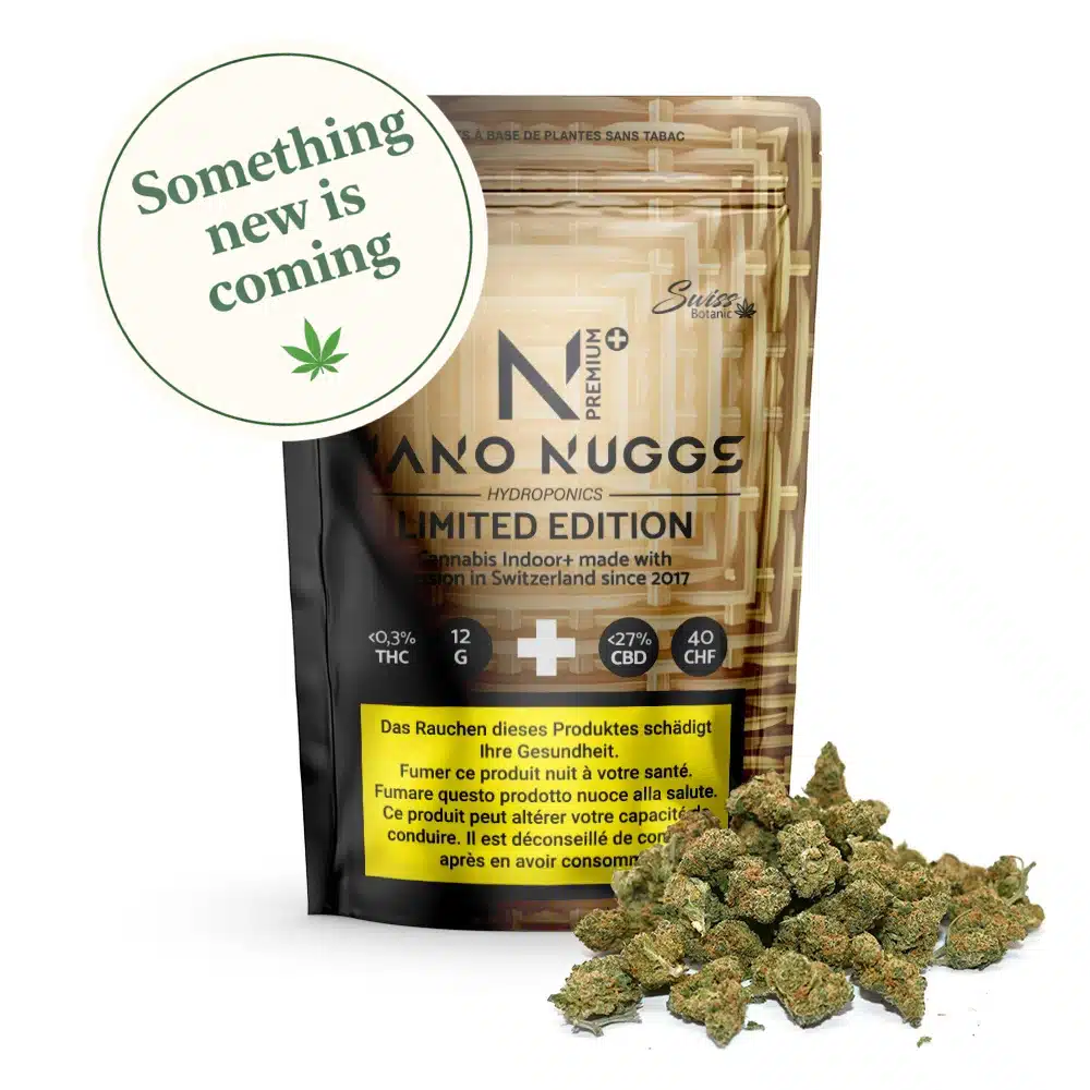A package labeled "Indoor CBD Flowers Nano Nuggs Premium Limited Edition - Gold - 0.3% THC" sits with CBD-rich cannabis buds in front, featuring a circular label reading "Something new is coming" and a cannabis leaf icon.