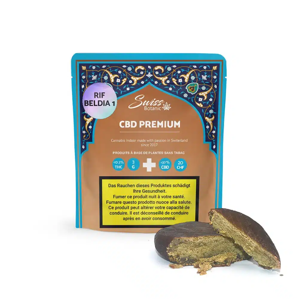 A package labeled "Rif Beldia #1 Hash CBD Premium - 0.3% THC" displays brown, crumbly hash cbd in front; health warning appears in German and French at the bottom.